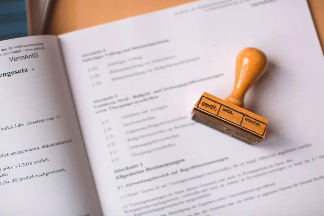 A laptop and a phone on a desk with a paper checklist and documents, representing a job application.