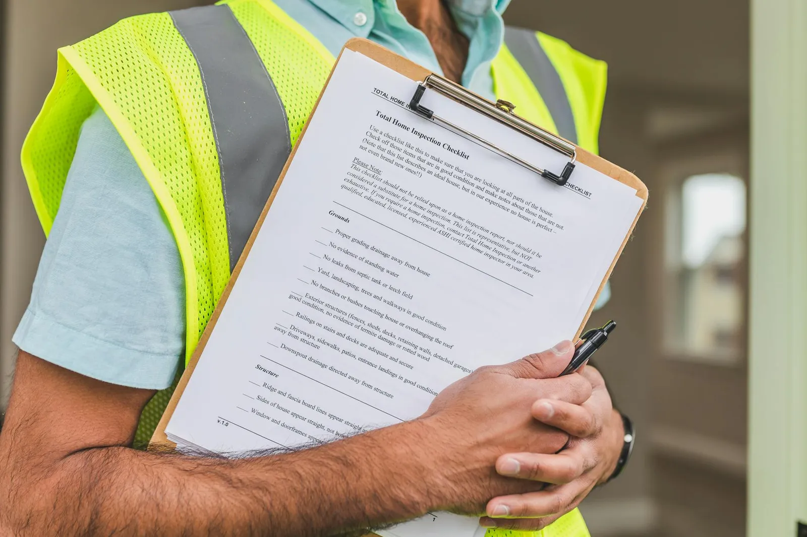 Review checklist and an envelope on the desk, with a smartphone out of focus nearby.